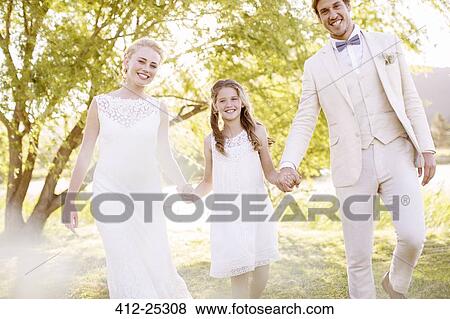 "Bride, bridegroom and bridesmaid walking in domestic garden" View Large Photo Image Stock Photo - "Bride, bridegroom and bridesmaid walking in domestic garden". Fotosearch