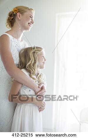 Bride embracing bridesmaid and looking out of window View Large Photo Image Stock Photography - Bride embracing bridesmaid and looking out of window. Fotosearch