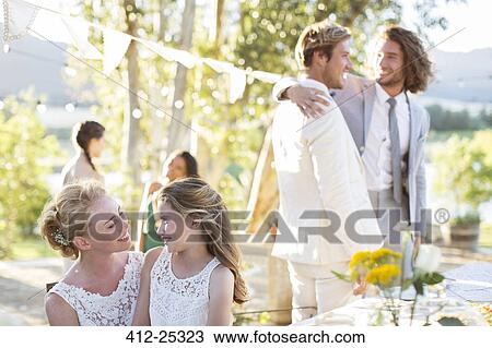 Bride talking to bridesmaid during wedding reception in domestic garden View Large Photo Image Stock Image - Bride talking to bridesmaid during wedding reception in domestic garden. Fotosearch