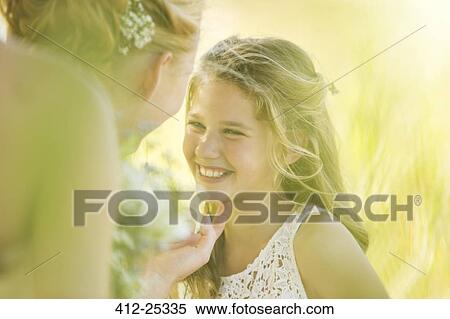 Stock Photography - Bride talking to Bridesmaid in domestic garden. Fotosearch