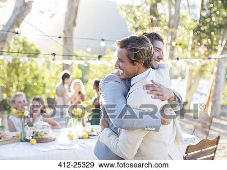 Bridegroom and best man embracing during wedding reception in domestic garden View Large Photo Image Stock Photo - Bridegroom and best man embracing during wedding reception in domestic garden. Fotosearch