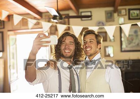 Bridegroom and best man photographing self in domestic room View Large Photo Image Stock Photo - Bridegroom and best man photographing self in domestic room. Fotosearch