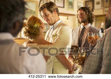 Bridegroom embracing bride during wedding reception in domestic room View Large Photo Image Stock Image - Bridegroom embracing bride during wedding reception in domestic room. Fotosearch