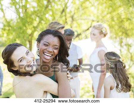 Bridesmaid and friend dancing during wedding reception in domestic garden View Large Photo Image Picture - Bridesmaid and friend dancing during wedding reception in domestic garden. Fotosearch