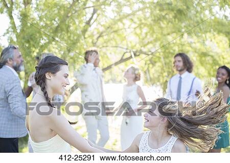 Bridesmaid and girl dancing during wedding reception in domestic garden View Large Photo Image Stock Image - Bridesmaid and girl dancing during wedding reception in domestic garden. Fotosearch