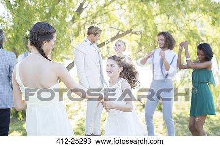 Bridesmaid and girl dancing during wedding reception in domestic garden View Large Photo Image Stock Image - Bridesmaid and girl dancing during wedding reception in domestic garden. Fotosearch