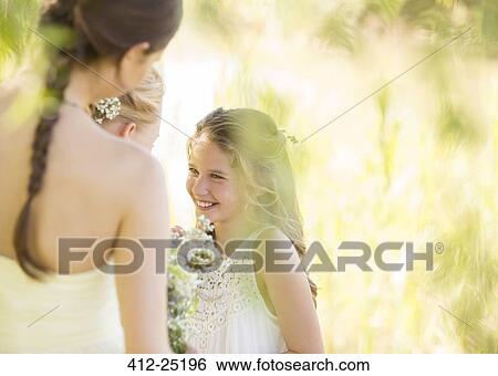 Stock Photograph - Bridesmaid with bouquet of flowers during wedding reception in garden. Fotosearch