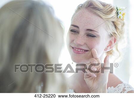 Stock Image - Matron of honor and bride facing each other and smiling. Fotosearch