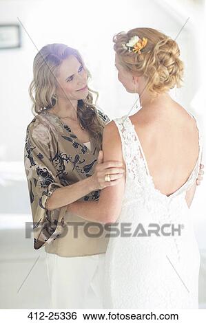 Stock Photograph - Matron of honor and bride talking in domestic room. Fotosearch