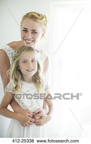 Stock Photo - Portrait of bride and bridesmaid in domestic room. Fotosearch