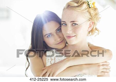 Portrait of bridesmaid embracing bride in bedroom View Large Photo Image Stock Photography - Portrait of bridesmaid embracing bride in bedroom. Fotosearch