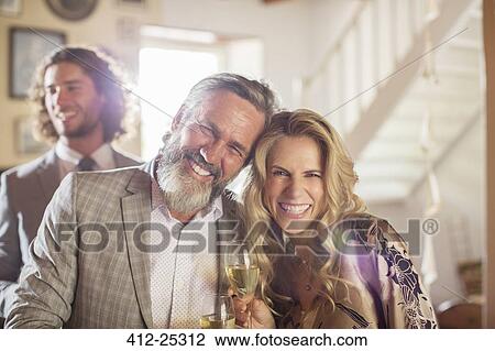 Stock Image - Portrait of smiling matron of honor and best man during wedding reception in domestic room. Fotosearch