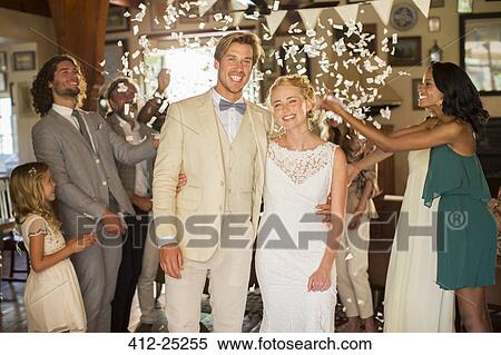 Portrait of smiling young couple standing in falling confetti during wedding reception View Large Photo Image Stock Photography - Portrait of smiling young couple standing in falling confetti during wedding reception. Fotosearch