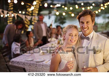 Portrait of young couple during wedding reception in domestic garden View Large Photo Image Stock Image - Portrait of young couple during wedding reception in domestic garden. Fotosearch