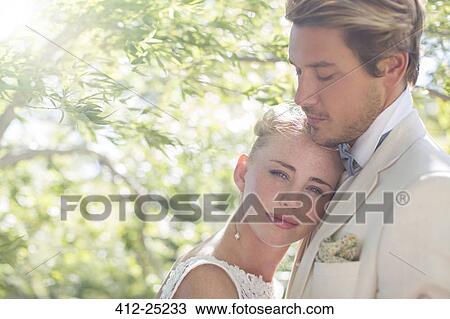 Stock Image - Portrait of young couple in domestic garden. Fotosearch