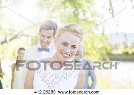 Stock Image - Portrait of young couple in domestic garden. Fotosearch