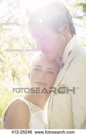 Stock Photograph - Portrait of young couple in domestic garden. Fotosearch