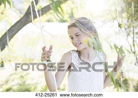 Smiling bridesmaid playing with decorations in domestic garden during wedding reception View Large Photo Image Stock Image - Smiling bridesmaid playing with decorations in domestic garden during wedding reception. Fotosearch