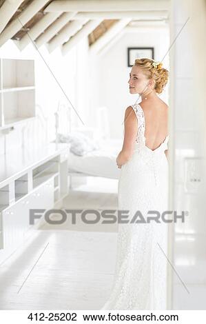 Young bride standing in sunny bedroom View Large Photo Image Stock Image - Young bride standing in sunny bedroom. Fotosearch