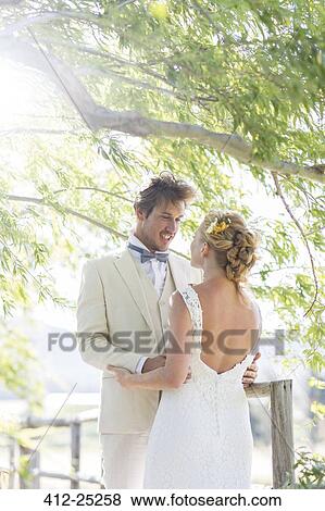 Young couple embracing on wooden bridge View Large Photo Image Stock Photo - Young couple embracing on wooden bridge. Fotosearch