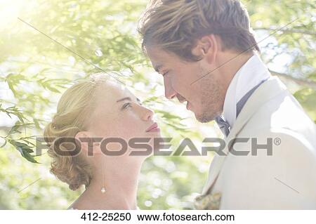 Young couple facing each other in domestic garden View Large Photo Image Stock Image - Young couple facing each other in domestic garden. Fotosearch