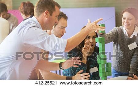 Stock Image - Business people stacking green blocks. Fotosearch