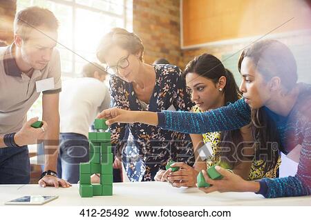 Stock Image - Creative business people stacking green blocks. Fotosearch