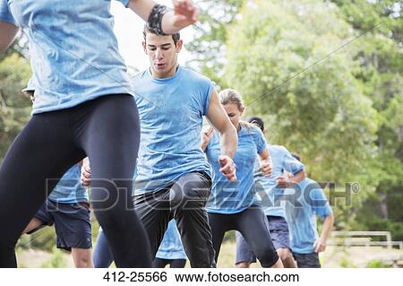 Determined man on boot camp obstacle course View Large Photo Image Stock Photograph - Determined man on boot camp obstacle course. Fotosearch