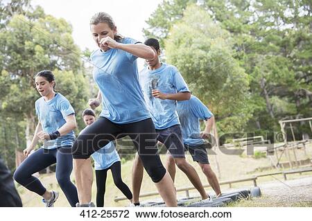 Determined people jumping tires on boot camp obstacle course View Large Photo Image Stock Image - Determined people jumping tires on boot camp obstacle course. Fotosearch