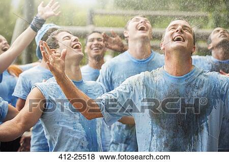 Stock Photo - Enthusiastic team enjoying rain at boot camp. Fotosearch
