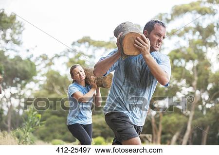 Man and woman running with logs on boot camp course View Large Photo Image Stock Photo - Man and woman running with logs on boot camp course. Fotosearch