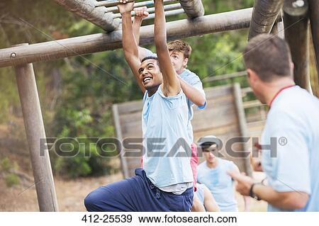 Man crossing monkey bars on boot camp obstacle course View Large Photo Image Stock Photo - Man crossing monkey bars on boot camp obstacle course. Fotosearch