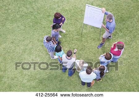 Man leading meeting at flipchart in field View Large Photo Image Picture - Man leading meeting at flipchart in field. Fotosearch