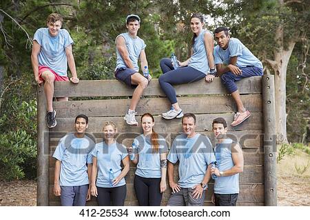 Picture - Portrait of confident team at wall on boot camp obstacle course. Fotosearch