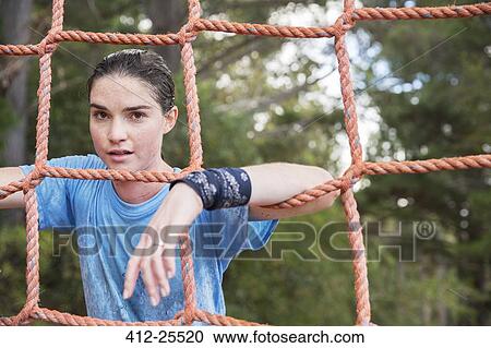 Portrait of confident woman leaning on net at boot camp View Large Photo Image Stock Image - Portrait of confident woman leaning on net at boot camp. Fotosearch