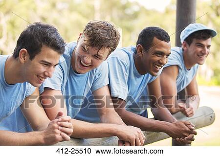 Smiling team leaning on railing at boot camp View Large Photo Image Stock Image - Smiling team leaning on railing at boot camp. Fotosearch