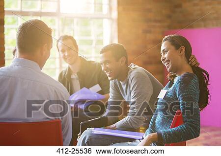 Stock Photograph - Smiling woman enjoying group therapy session. Fotosearch