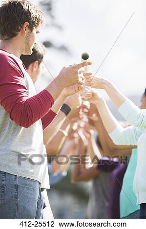 Stock Image - Team balancing pole with fingertips. Fotosearch