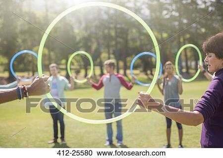 Team connected in circle by plastic hoops View Large Photo Image Stock Image - Team connected in circle by plastic hoops. Fotosearch