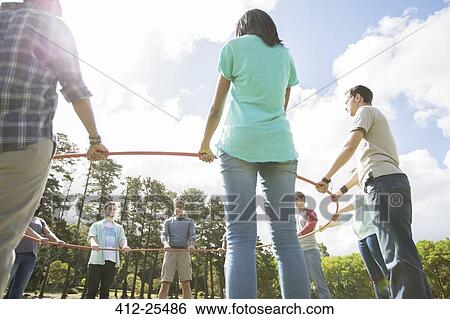 Team forming connecting circle around plastic hoop View Large Photo Image Stock Photograph - Team forming connecting circle around plastic hoop. Fotosearch