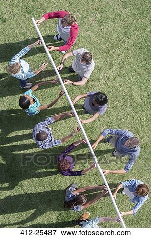 Stock Photo - Team holding pole up with fingertips. Fotosearch