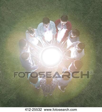 Team in circle surrounding glowing orb View Large Photo Image Stock Image - Team in circle surrounding glowing orb. Fotosearch