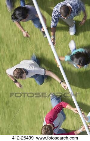 Stock Photo - Team running and balancing pole on fingertips. Fotosearch