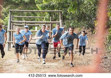 Stock Image - Team running on boot camp obstacle course. Fotosearch