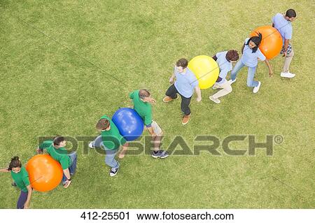 Teammates performing fitness ball team building activity View Large Photo Image Stock Image - Teammates performing fitness ball team building activity. Fotosearch