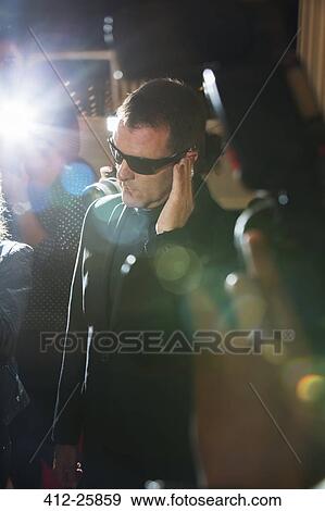 Bodyguard listening to earpiece at event View Large Photo Image Stock Photo - Bodyguard listening to earpiece at event. Fotosearch