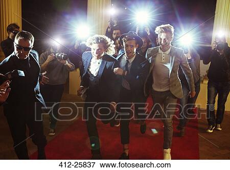 Celebrities running from paparazzi photographers at red carpet event View Large Photo Image Stock Photo - Celebrities running from paparazzi photographers at red carpet event. Fotosearch