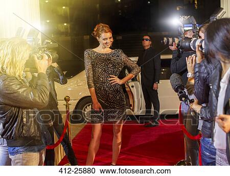 Celebrity arriving and posing for paparazzi photographers at red carpet event View Large Photo Image Stock Image - Celebrity arriving and posing for paparazzi photographers at red carpet event. Fotosearch