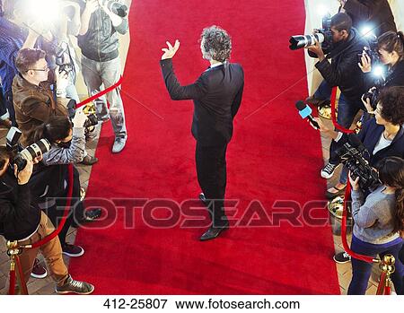 Celebrity arriving at red carpet event and waving at photographing paparazzi View Large Photo Image Stock Photo - Celebrity arriving at red carpet event and waving at photographing paparazzi. Fotosearch