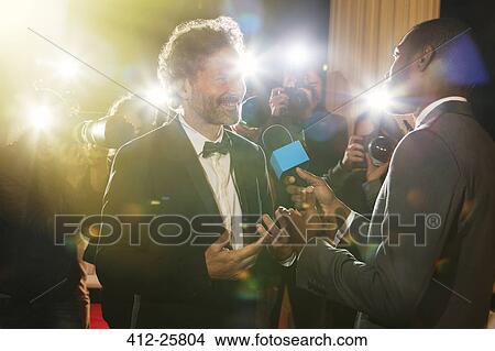 Picture - Celebrity being interviewed and photographed by paparazzi at event. Fotosearch
